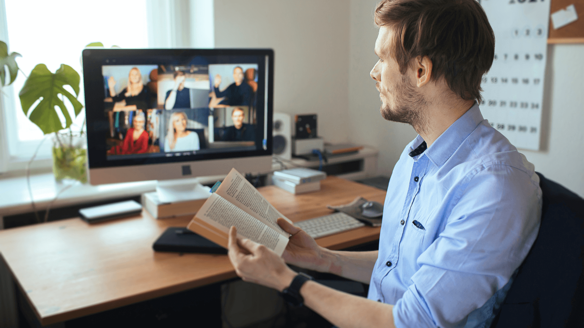 Man looking at computer with multiple people
